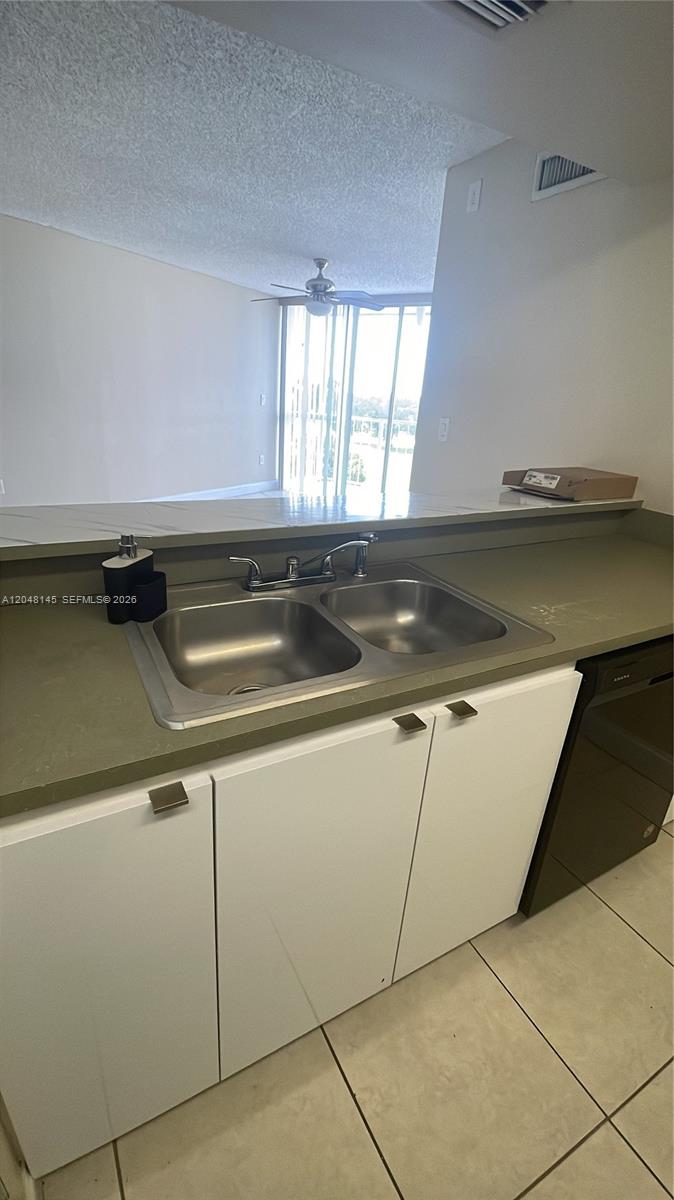 A kitchen sink with a faucet is set into a countertop above white cabinets — 6955 NW 186th St # F505, Hialeah FL 33015, HIALEAH, FL