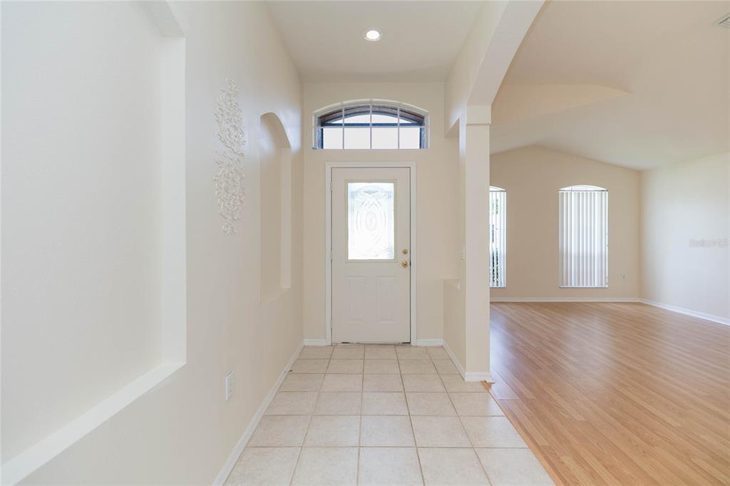 An entryway with tiled flooring leads to a front door with a decorative glass insert — 22704 RODERICK DRIVE, LAND O LAKES, FL