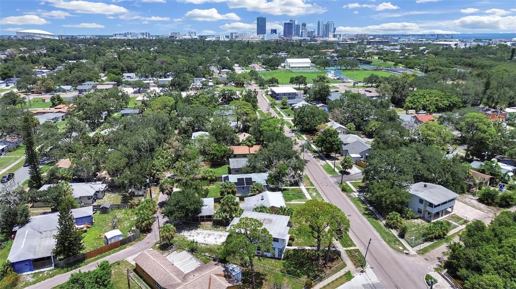 An aerial view shows a residential neighborhood with houses, trees, and a distant city skyline — 2371 7TH STREET S, ST PETERSBURG, FL