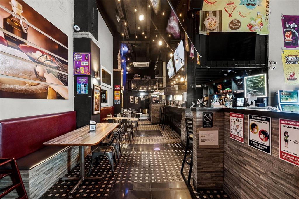 A restaurant interior features wooden tables, a bar area, and decorative posters on the walls — 301 SAN JUSTO, SAN JUAN, PR