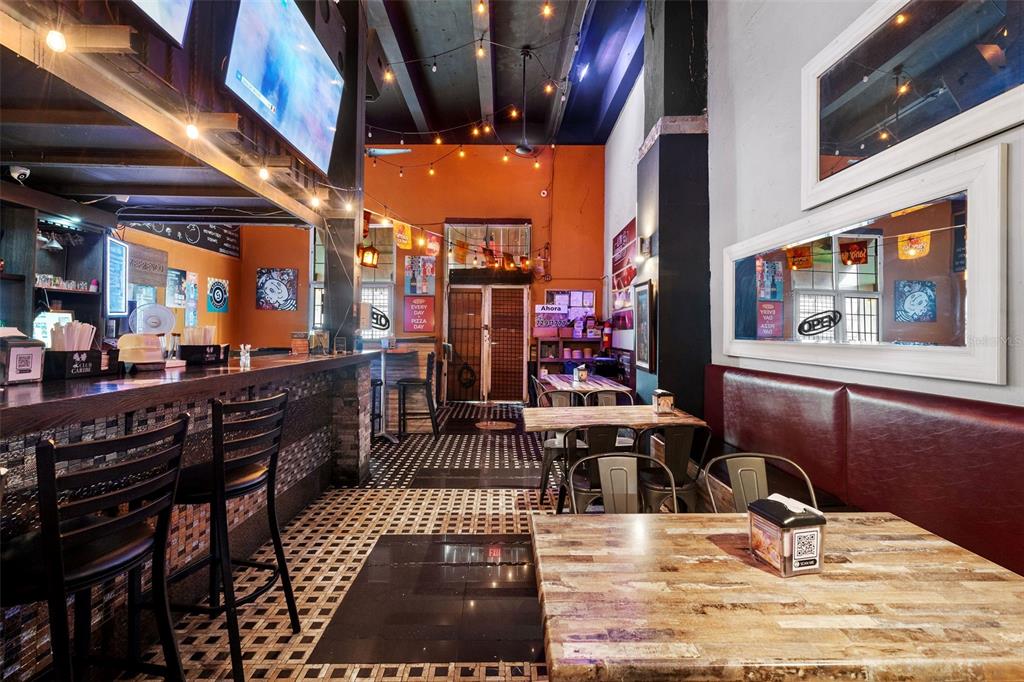 A restaurant interior features a bar with stools, wooden tables, and string lighting — 301 SAN JUSTO, SAN JUAN, PR