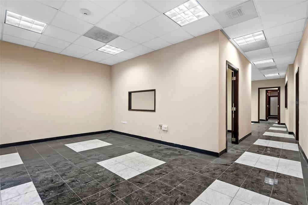 An empty office space features beige walls, a drop ceiling, and a black-and-white tiled floor — 301 SAN JUSTO, SAN JUAN, PR
