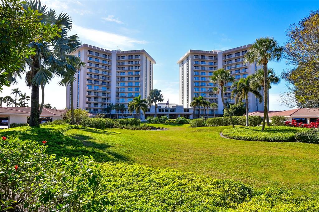 Two tall residential buildings stand behind a large green lawn with palm trees — 2301 GULF OF MEXICO DRIVE UNIT 43N, LONGBOAT KEY, FL