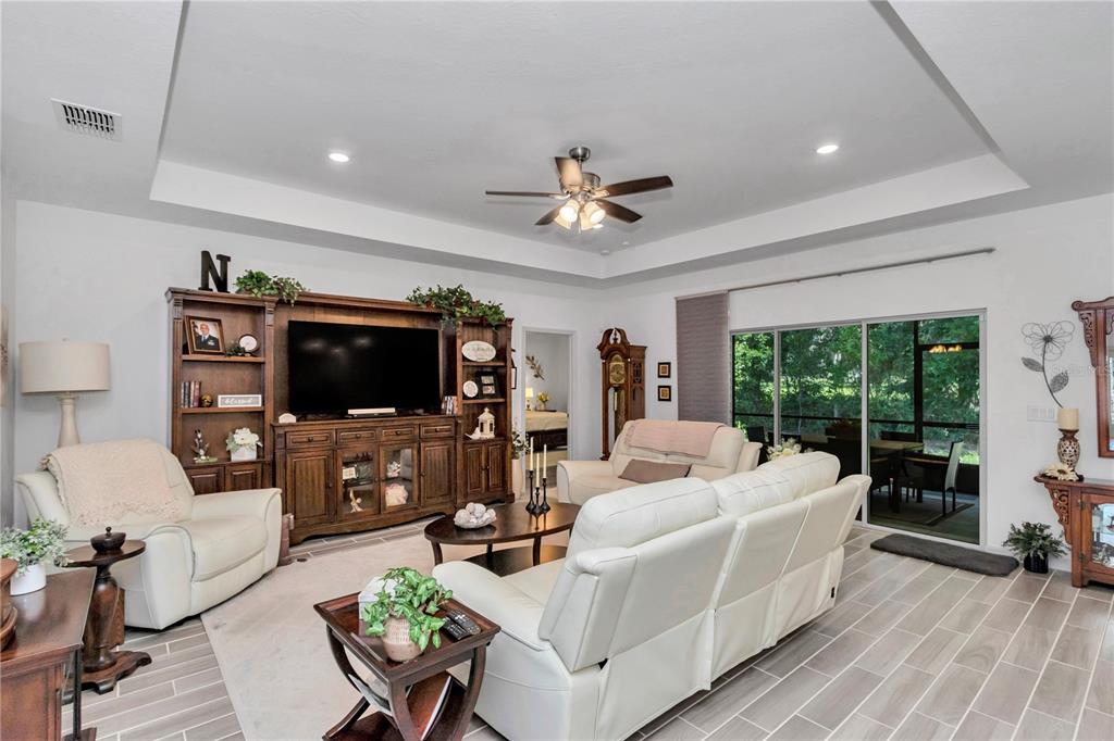 A screened-in patio features a dining set, ceiling fan, and views of a grassy yard — 7663 SW 74TH LOOP, OCALA, FL