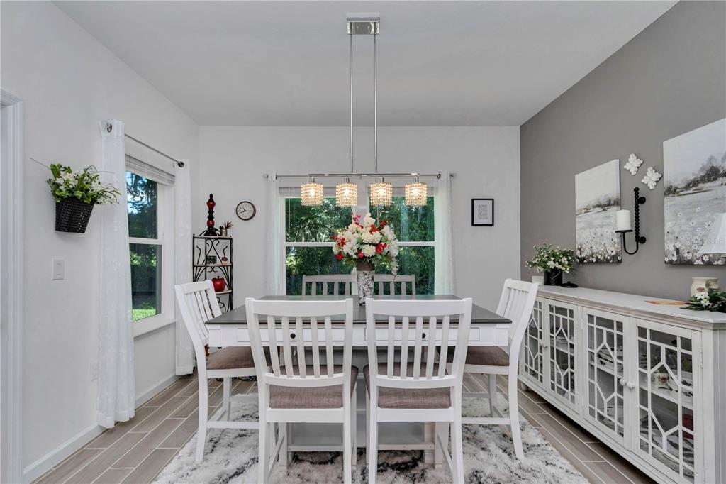 A kitchen with white cabinets, a large island, and an adjacent dining area — 7663 SW 74TH LOOP, OCALA, FL