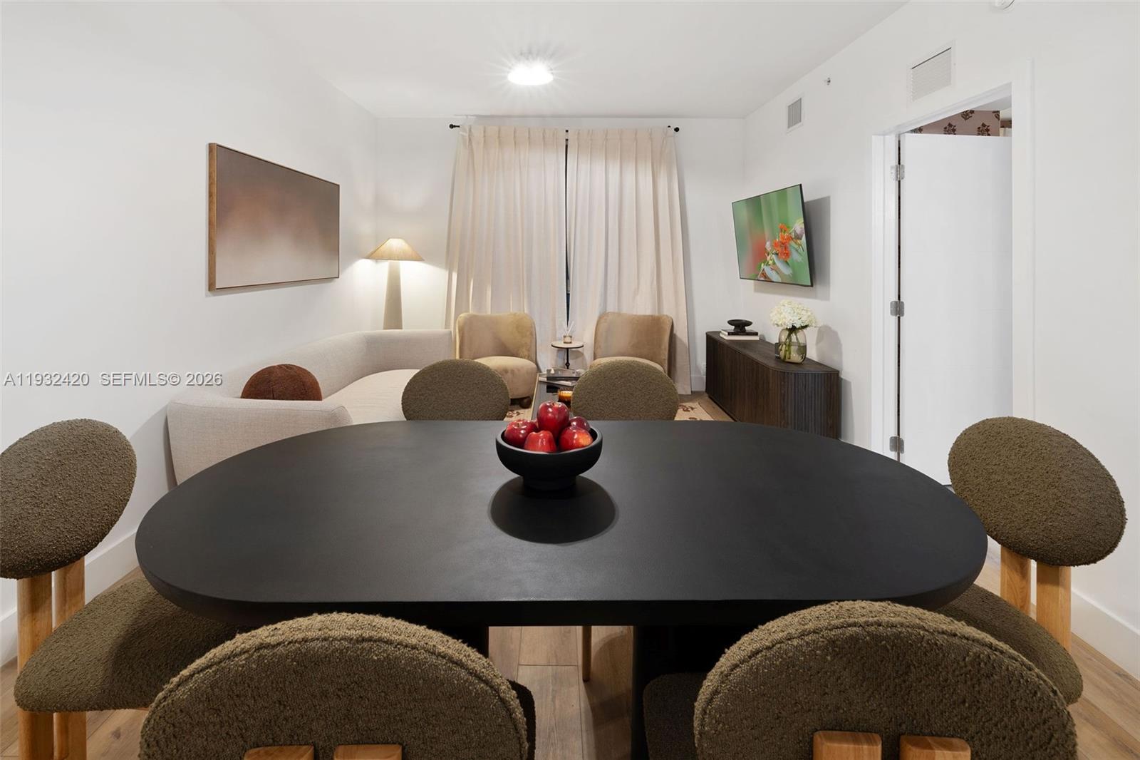 A dining area and living room feature light wood flooring, neutral furniture, and modern lighting — 1542 NW 2nd St # 105, Miami FL 33125, MIAMI, FL