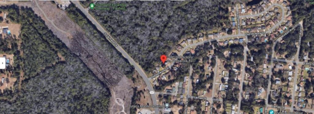 This is an aerial map view showing a residential property located near a wooded area — 7600 OLD HICKORY DRIVE, PENSACOLA, FL