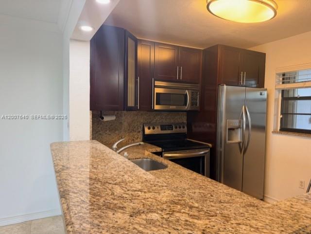 A kitchen features dark wood cabinets, granite countertops, and stainless steel appliances — 10825 SW 112th Ave # 307, Miami FL 33176, MIAMI, FL
