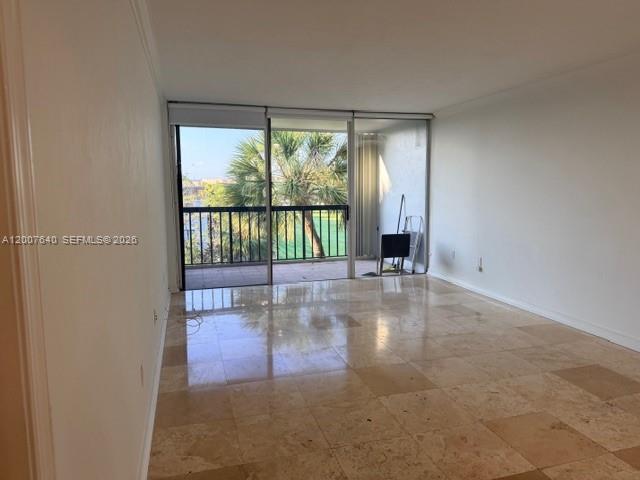 An empty room with light-colored tile flooring and a sliding glass door leading to a balcony — 10825 SW 112th Ave # 307, Miami FL 33176, MIAMI, FL