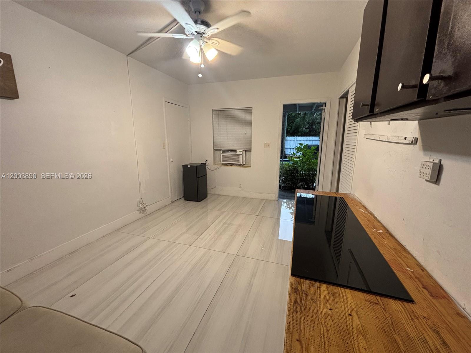 This kitchen area features light-colored tile flooring, a wooden countertop, and a ceiling fan — 250 SE Park St # 3, Dania Beach FL 33004, DANIA BEACH, FL