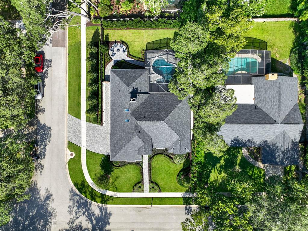 An aerial view shows a house with a screened pool, patio, and large backyard trees — 1054 WHISPERING COVE, CASSELBERRY, FL
