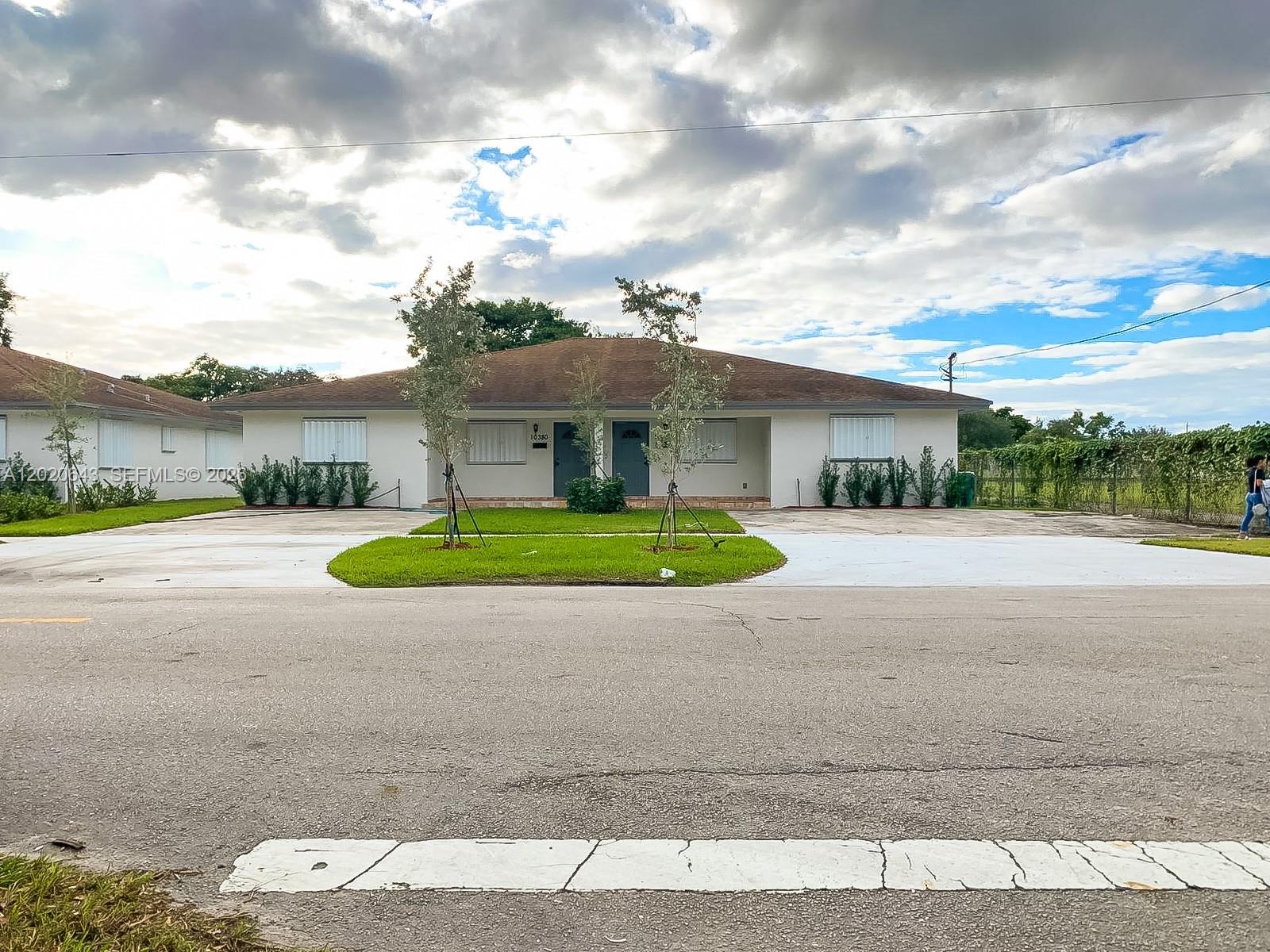 A single-story duplex with a brown roof, white exterior, and two adjacent front entrances — 10380 NW 10th Ave # 10380, Miami FL 33150, MIAMI, FL