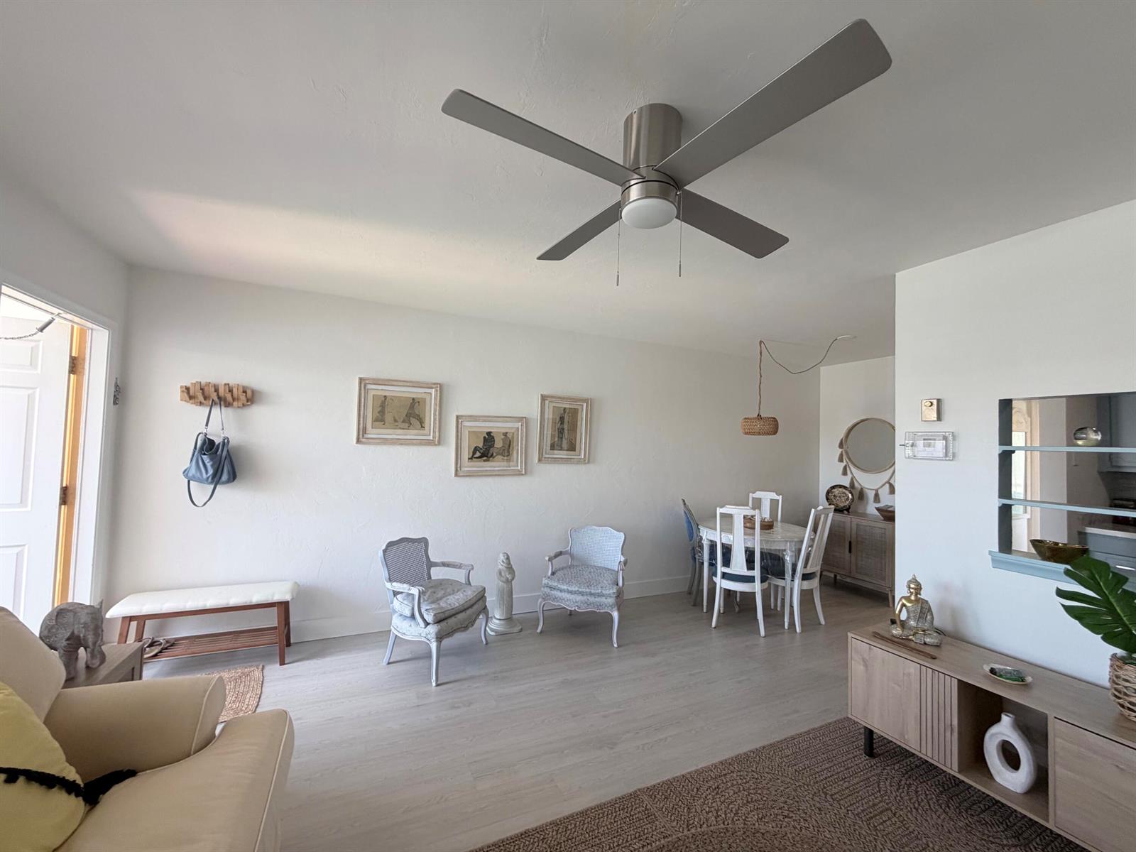A living and dining area features light wood flooring, a ceiling fan, and white walls — 3322 Cynthia Lane # 207, FL 33461, FL