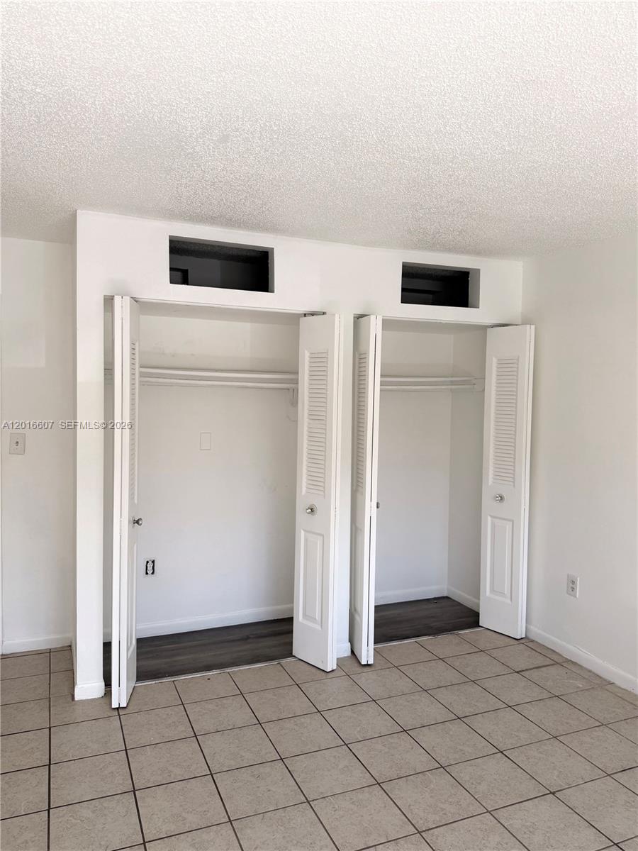 A room features two white louvered-door closets with open storage compartments above them — 6990 NW 186th St # 210A, Hialeah FL 33015, HIALEAH, FL