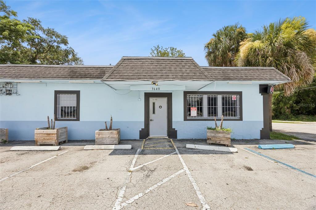 A single-story commercial building with a light blue exterior, dark trim, and a paved parking lot — 3640 SANFORD AVENUE, SANFORD, FL