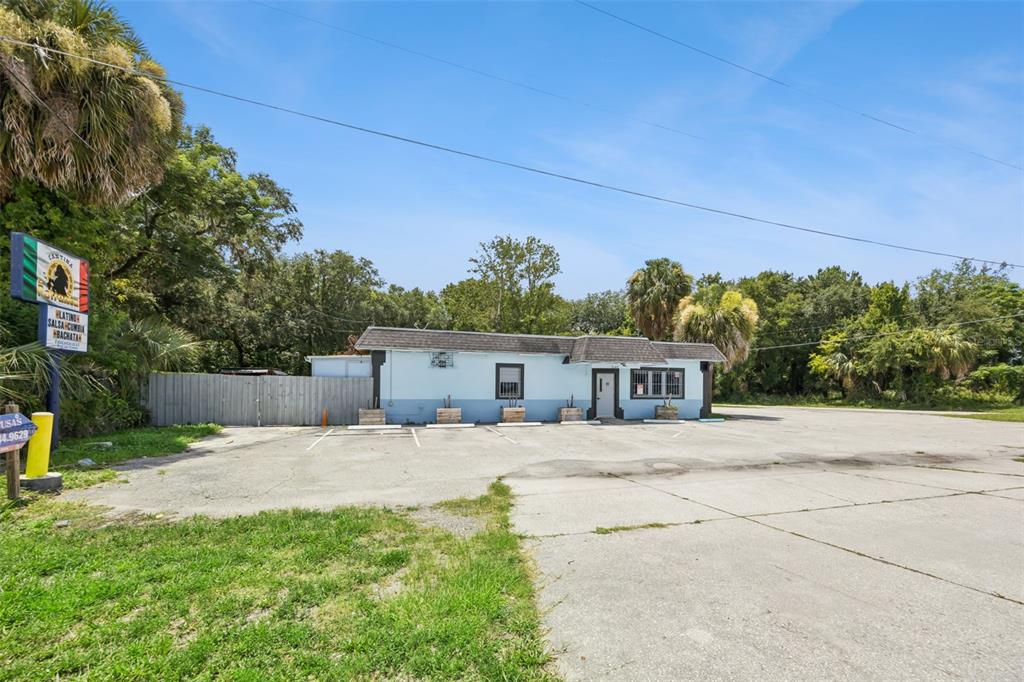 A single-story light blue building with a parking lot and a sign in the foreground — 3640 SANFORD AVENUE, SANFORD, FL