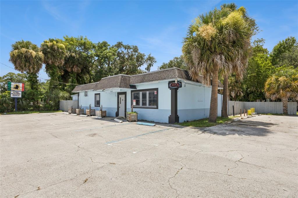 A light blue commercial building with a parking lot and palm trees under a blue sky — 3640 SANFORD AVENUE, SANFORD, FL