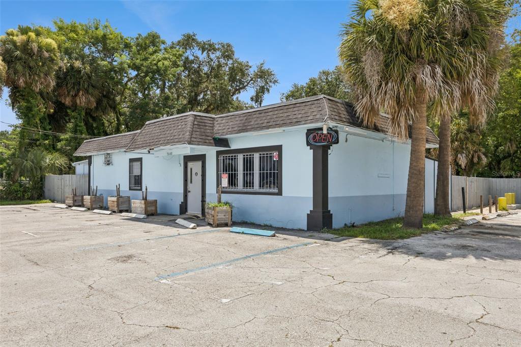 A light blue commercial building with a dark shingled roof and a paved parking lot — 3640 SANFORD AVENUE, SANFORD, FL