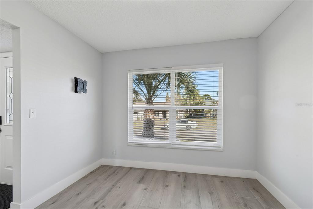 An empty room with light gray walls, wood-look flooring, and a window with white blinds — 3309 BRIARWOOD LANE, SAFETY HARBOR, FL