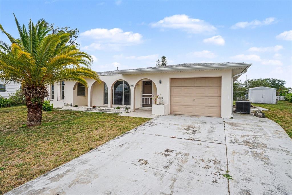 A single-story house with a beige stucco exterior, arched porch, and an attached garage — 6535 MARIUS ROAD, NORTH PORT, FL
