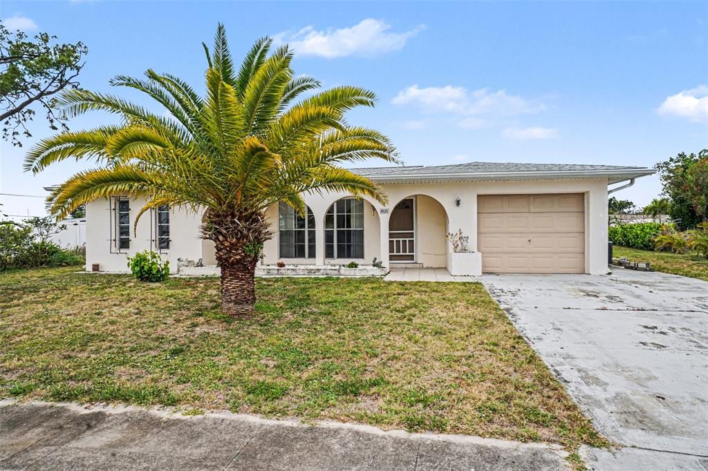 A single-story house with a palm tree, arched windows, and a tan garage door — 6535 MARIUS ROAD, NORTH PORT, FL