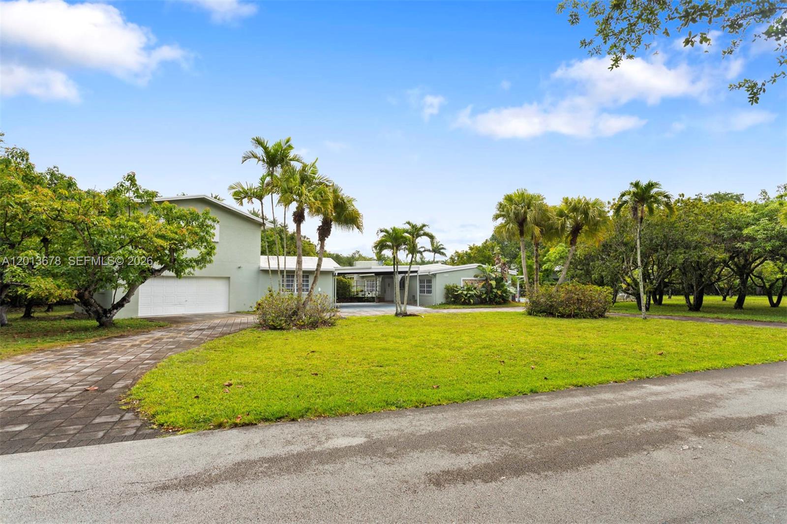 A light green single-story house with a paved driveway and palm trees in the yard — 10851 SW 68th Ave, Pinecrest FL 33156, PINECREST, FL