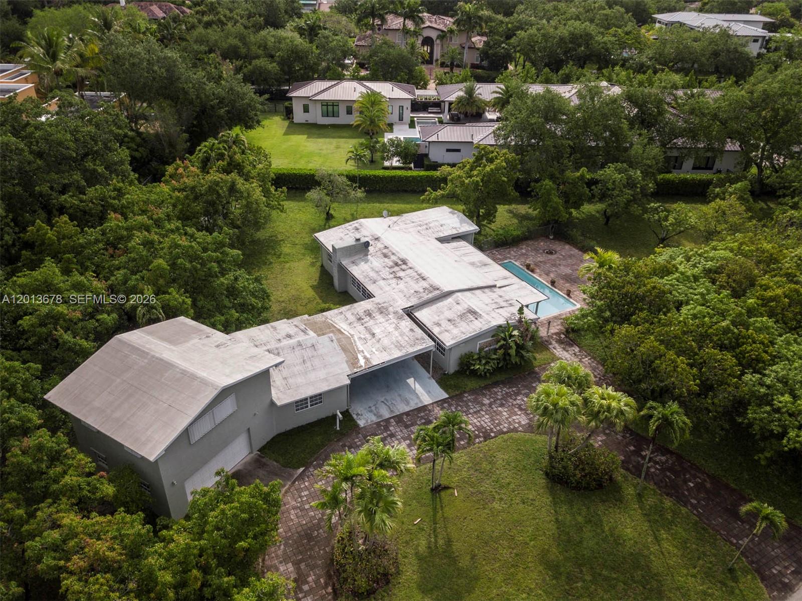 An aerial view shows a house with a flat roof, a pool, and a paved driveway — 10851 SW 68th Ave, Pinecrest FL 33156, PINECREST, FL