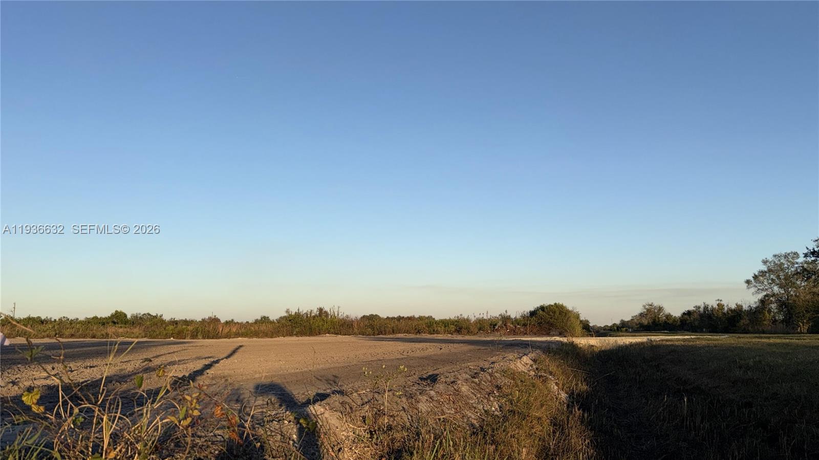 A flat, cleared dirt lot sits under a clear blue sky — 19946 NW 254 st, Okeechobee FL 34972, OKEECHOBEE, FL