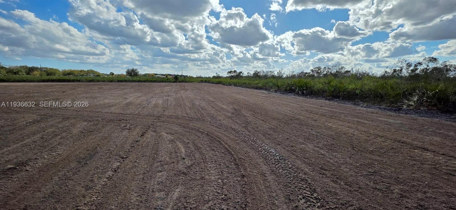 A wide, flat, cleared dirt lot under a cloudy blue sky — 19946 NW 254 st, Okeechobee FL 34972, OKEECHOBEE, FL