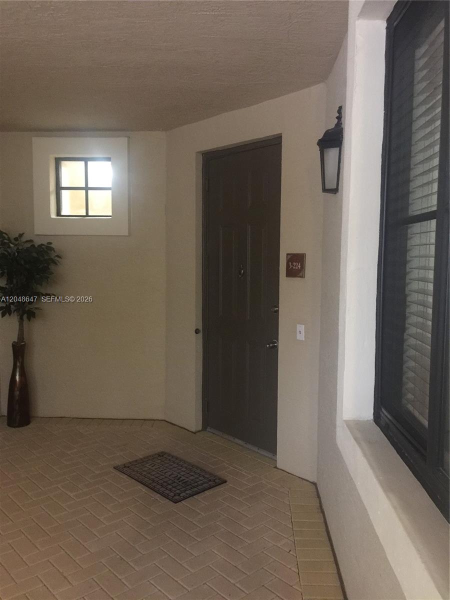 An open door reveals a tiled entryway leading into a bright, open-concept living space — 2900 NW 125th Ave # 224, Sunrise FL 33323, SUNRISE, FL