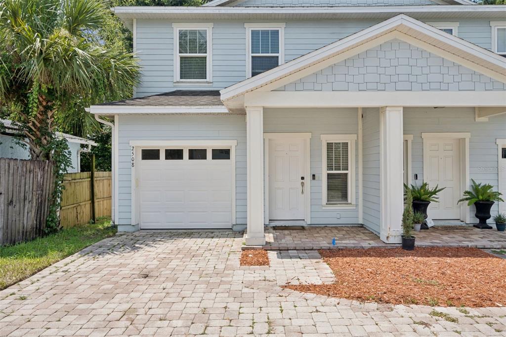 A light blue two-story townhouse features a single-car garage and a paved driveway — 2508 E CHURCH STREET, ORLANDO, FL