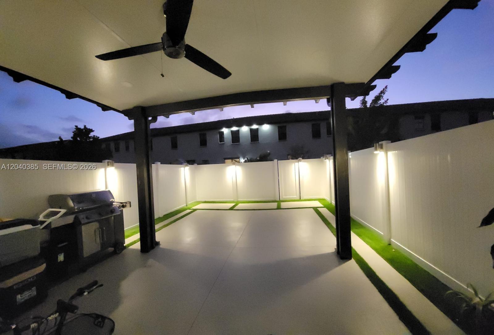 A covered patio features a ceiling fan, a grill, and a fenced yard with artificial turf — 11038 W 32nd Ln # 11038, Hialeah FL 33018, HIALEAH, FL