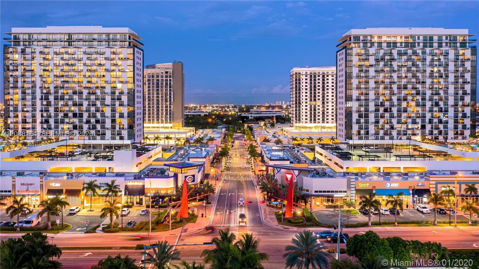An aerial view shows a commercial plaza with two large residential buildings at dusk — 5350 NW 84th Ave # 1018, Doral FL 33166, DORAL, FL