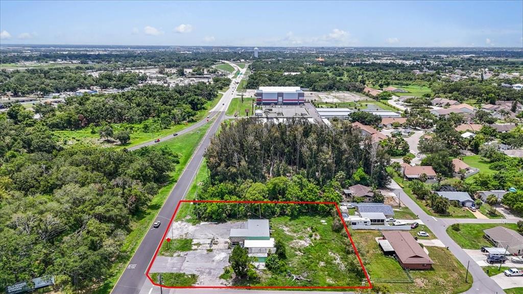 An aerial view shows a commercial property with a building and parking lot outlined in red — 4223 US HIGHWAY 19, PALMETTO, FL