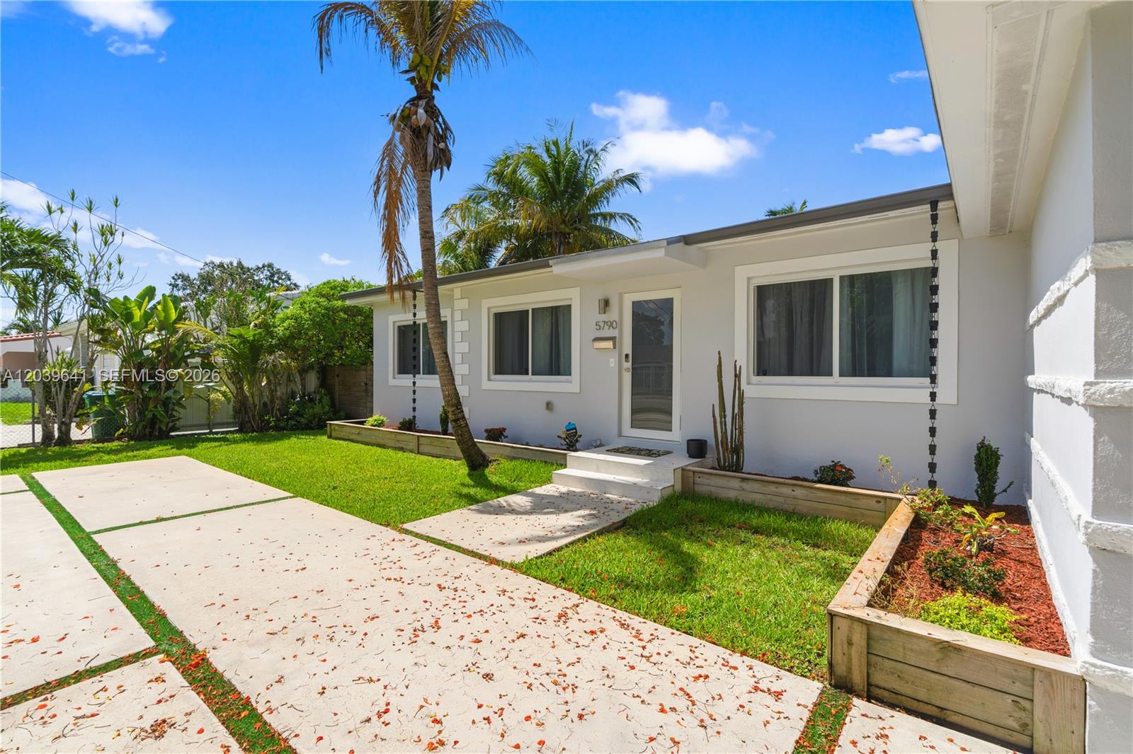 A single-story house features a concrete driveway, a palm tree, and raised garden beds — 5790 SW 3rd St, Miami FL 33144, MIAMI, FL