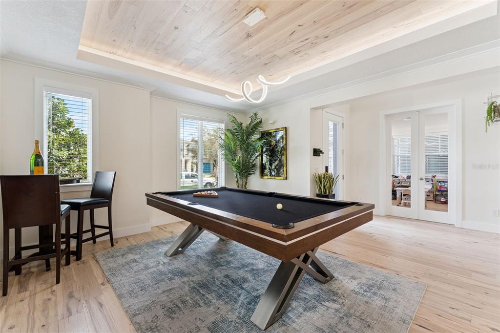 A game room features a pool table, wood-plank ceiling, and light wood flooring — 12618 SNELL LANE, ORLANDO, FL
