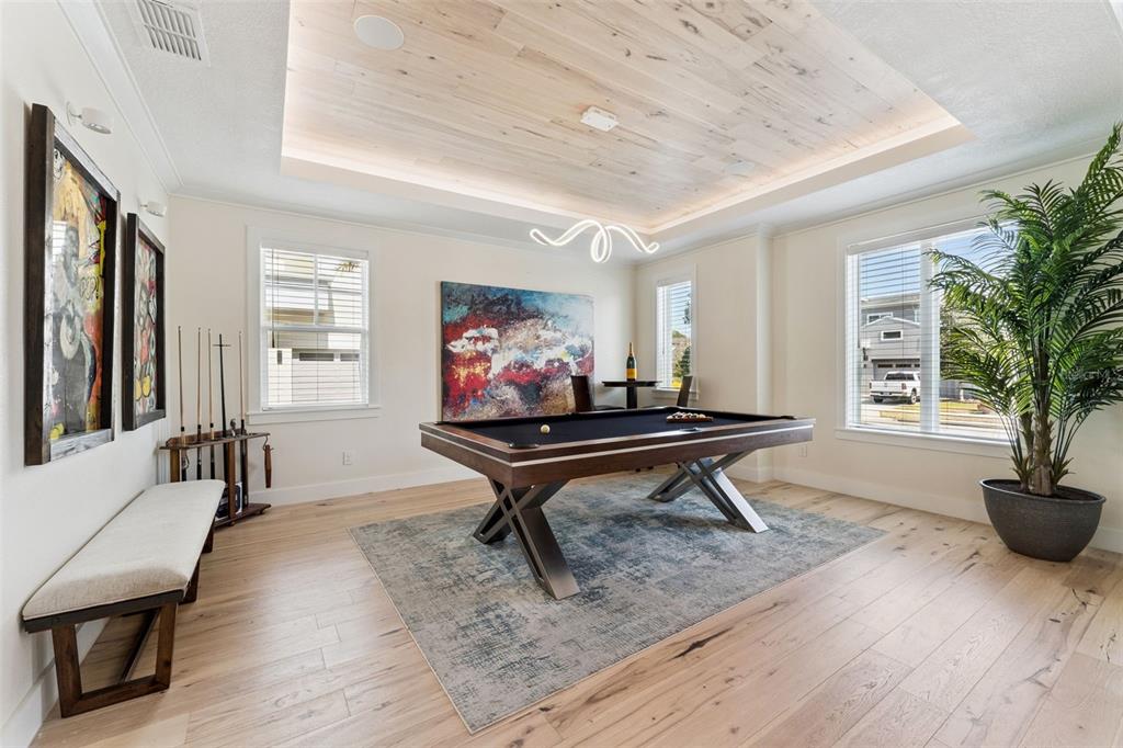 A game room features a pool table, light wood flooring, a tray ceiling, and wall art — 12618 SNELL LANE, ORLANDO, FL