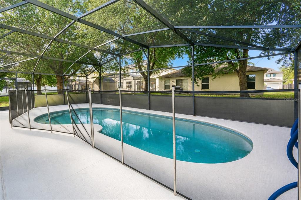 A swimming pool enclosed by a screen cage and a removable safety fence — 1503 BLUE HORIZON DRIVE, CLERMONT, FL