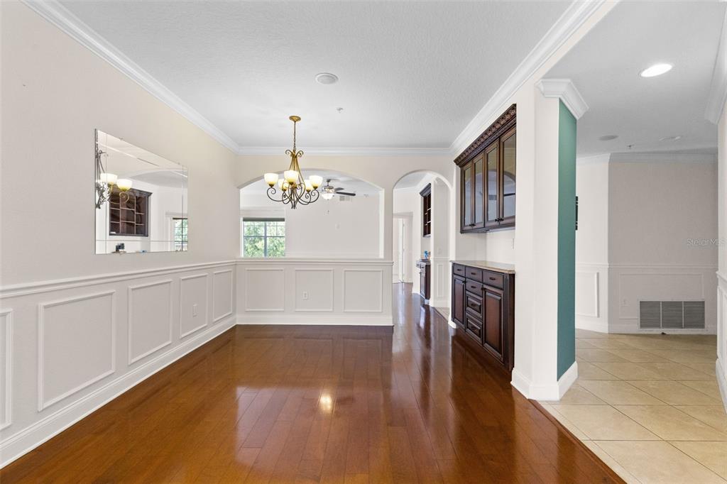 A dining room features hardwood floors, white wainscoting, a chandelier, and a built-in hutch — 917 LOTUS VISTA DRIVE UNIT 201, ALTAMONTE SPRINGS, FL