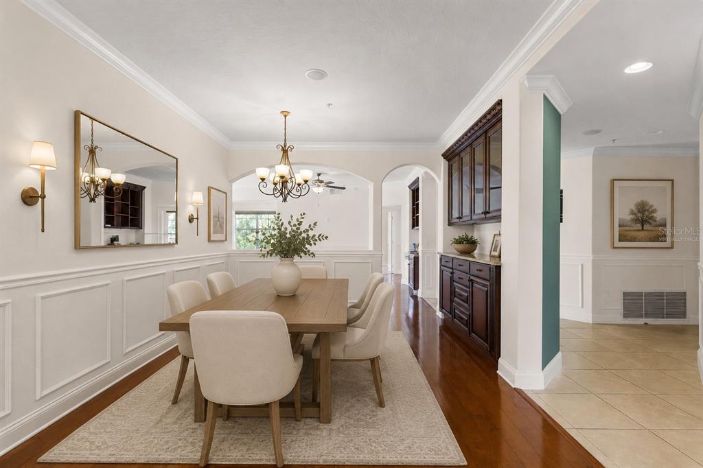 A dining room with a wooden table, upholstered chairs, a chandelier, and dark wood cabinetry — 917 LOTUS VISTA DRIVE UNIT 201, ALTAMONTE SPRINGS, FL