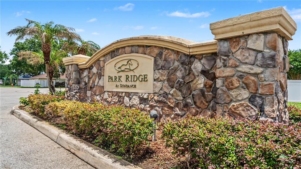 A stone monument sign for Park Ridge at Sundance stands beside a paved road — 3005 PARK RIDGE AVENUE, MULBERRY, FL