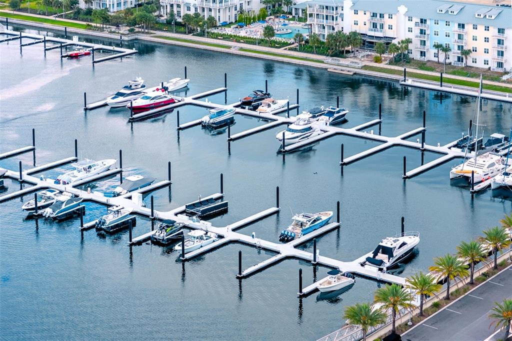 An aerial view shows a marina with numerous boats docked at white floating piers — 5120 MARINA WAY UNIT 9907, TAMPA, FL