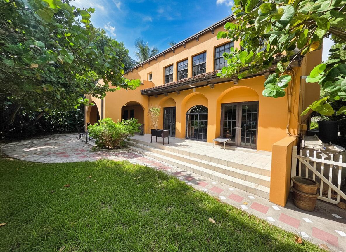 A two-story yellow stucco house with arched doorways, a tiled patio, and a grassy yard — 4200 N Surf Road, Hollywood FL 33019, HOLLYWOOD, FL