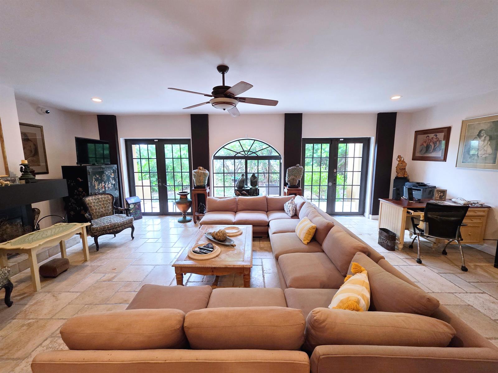A spacious living room features a large sectional sofa, tile flooring, and glass-paned double doors — 4200 N Surf Road, Hollywood FL 33019, HOLLYWOOD, FL