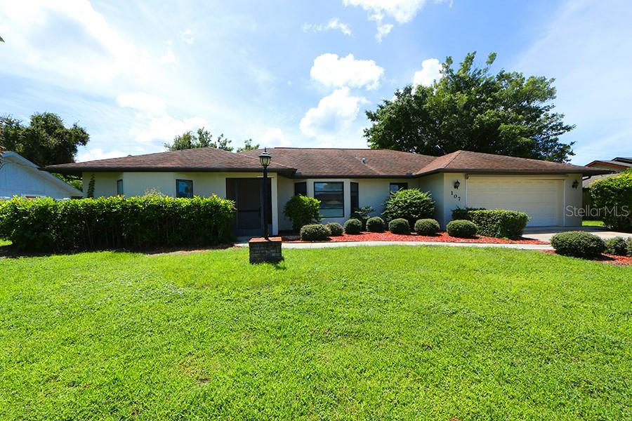 A single-story house with a brown roof, beige exterior, and a large front lawn — 147 HOURGLASS DRIVE, VENICE, FL