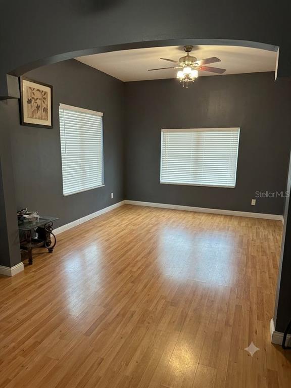An empty room with dark gray walls, light wood flooring, and a ceiling fan — 1410 E 21ST AVENUE, TAMPA, FL