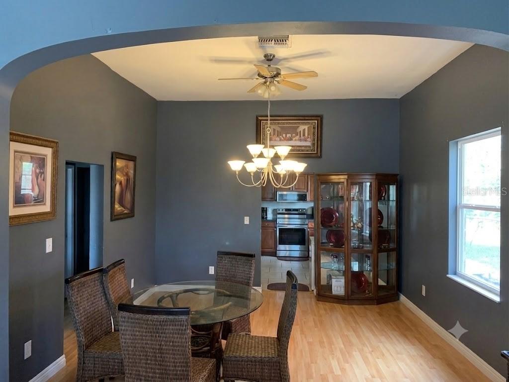 A dining room with dark gray walls, a glass table, wicker chairs, and a chandelier — 1410 E 21ST AVENUE, TAMPA, FL