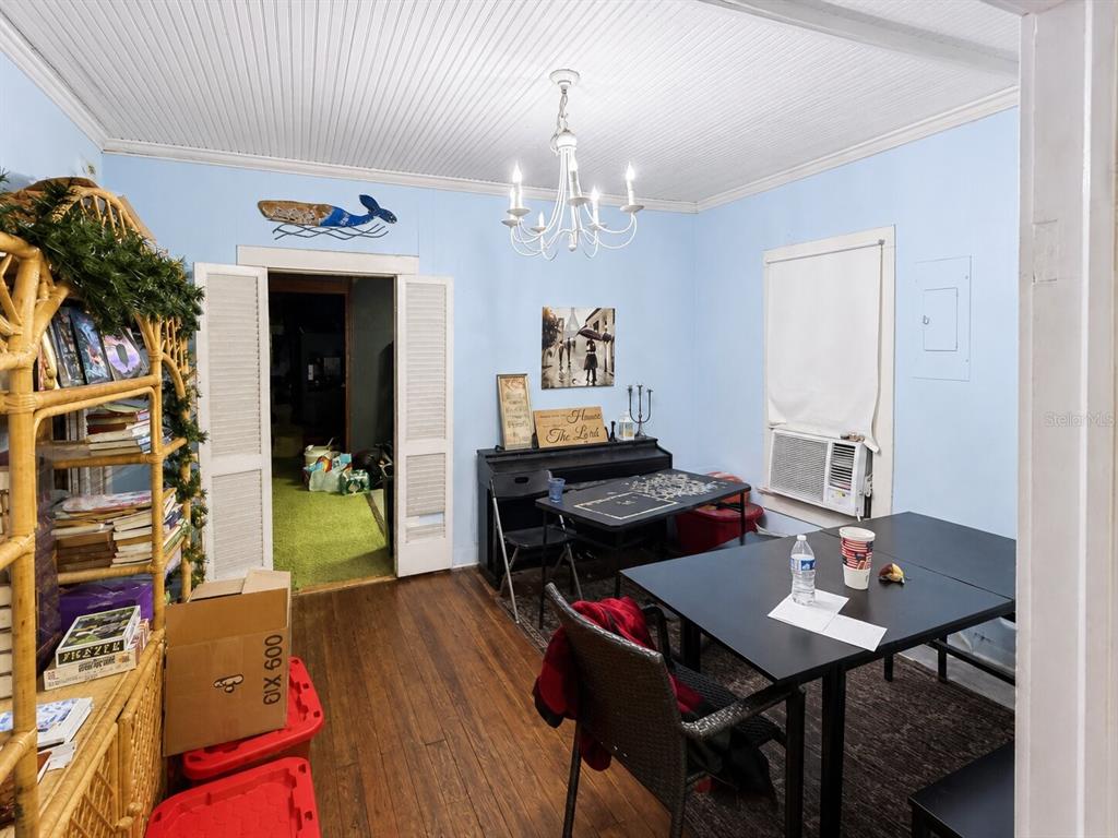 A dining room with light blue walls, a white chandelier, and a dark table — 129 S MILLS AVENUE, ARCADIA, FL