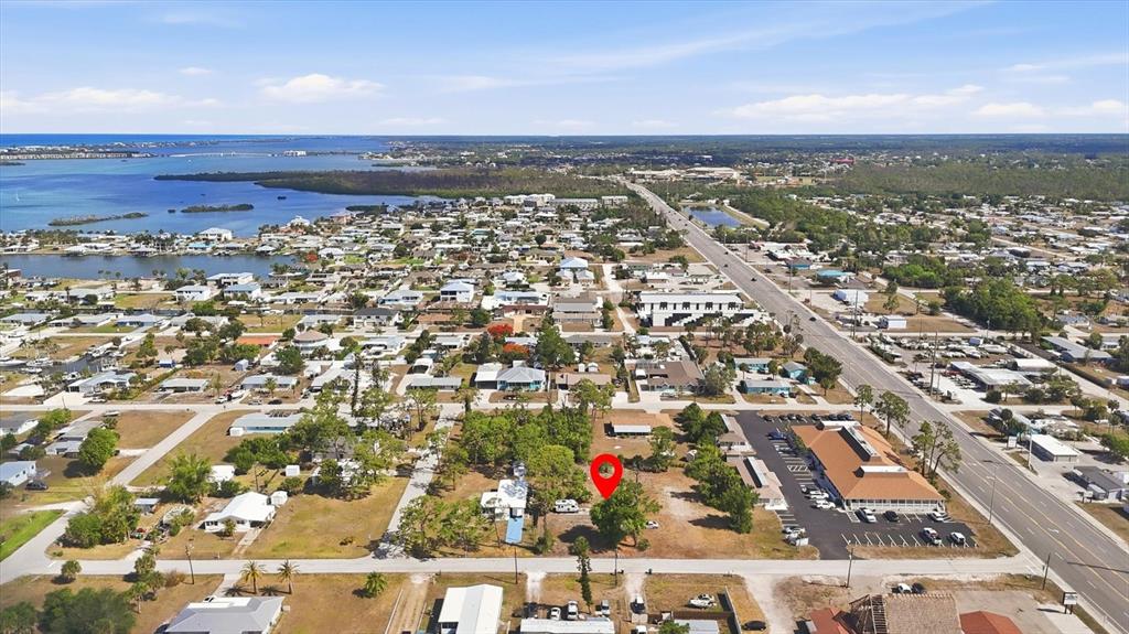 An aerial view shows a vacant lot marked with a red pin near a road — 1970 KENTUCKY AVENUE, ENGLEWOOD, FL