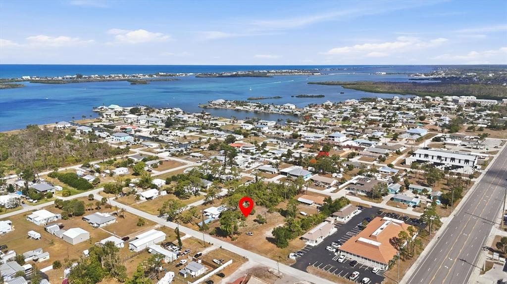 An aerial view shows a vacant lot marked with a red pin near a coastal town — 1970 KENTUCKY AVENUE, ENGLEWOOD, FL